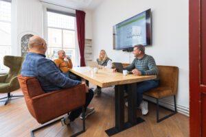 Teamleden van Energievolutie aan het vergaderen aan een tafel